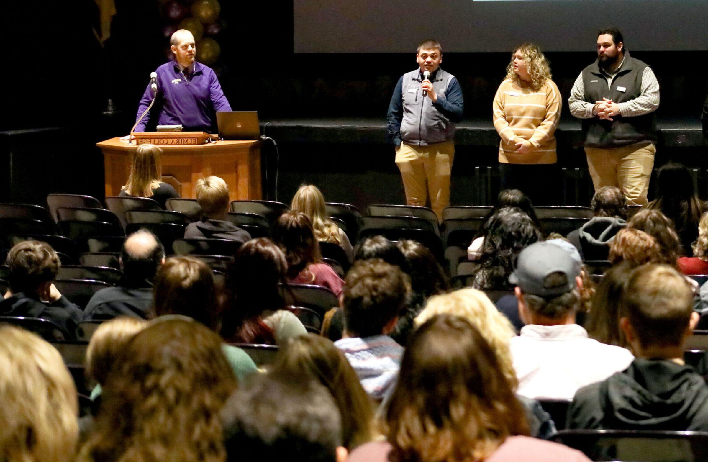 Admissions counselors speak with a crowd of guests in the Gibson Theatre