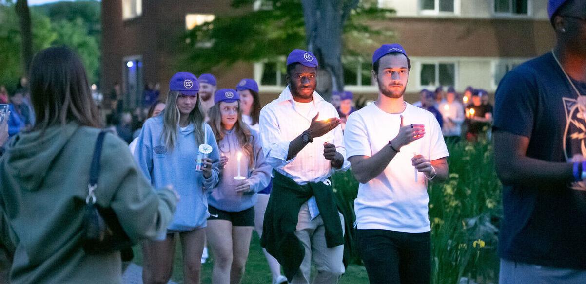 Students walk with candles during Candlelight